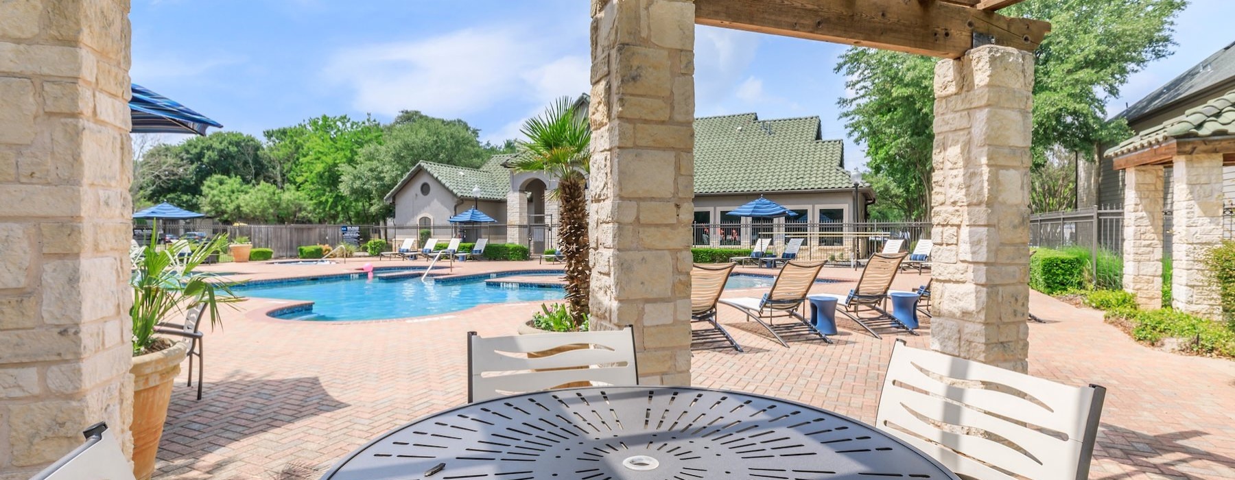 a poolside lounge with tables and chairs